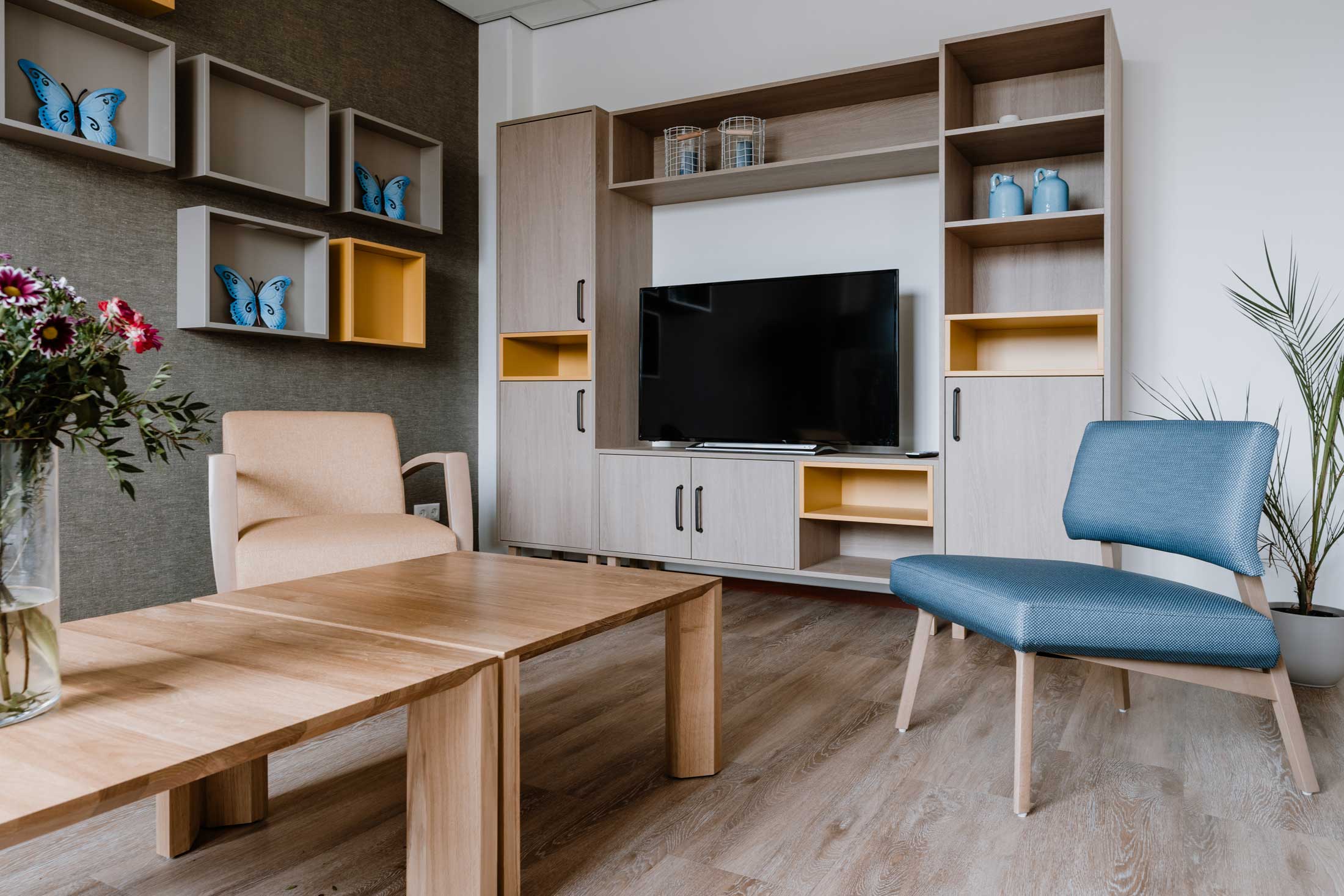 Sfeer concept turnkey woonkamer met blauwe stoel en lage tafel